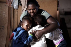 A teacher embraces children  at a pre-school in Cape Town's Khayelitsha township